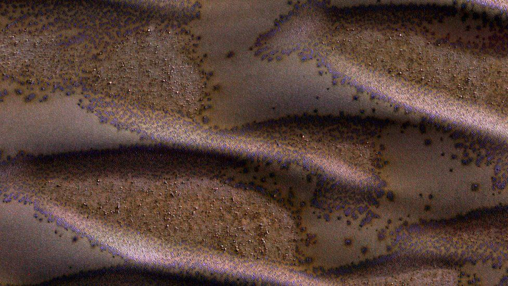 Las dunas de arena cubren buena parte de este terreno. Las que vemos aquí están en el hemisferio sur del planeta. "Estan recibiendo la suficienta luz solar como para empezar a descongelar su capa estacional de dióxido de carbono", se explica en el sitio de la NASA.